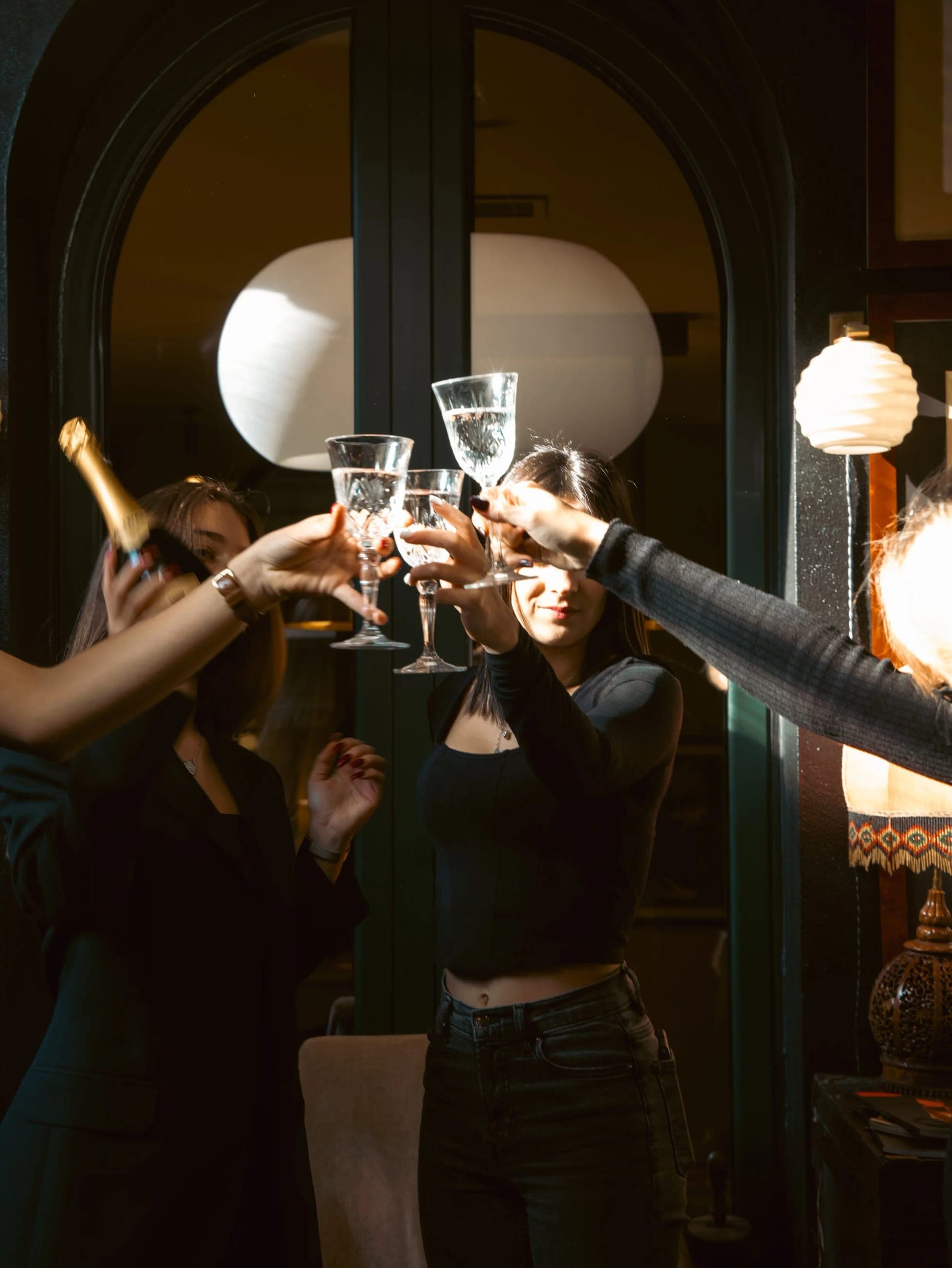 Guests raising their glasses in a toast in a warmly lit room