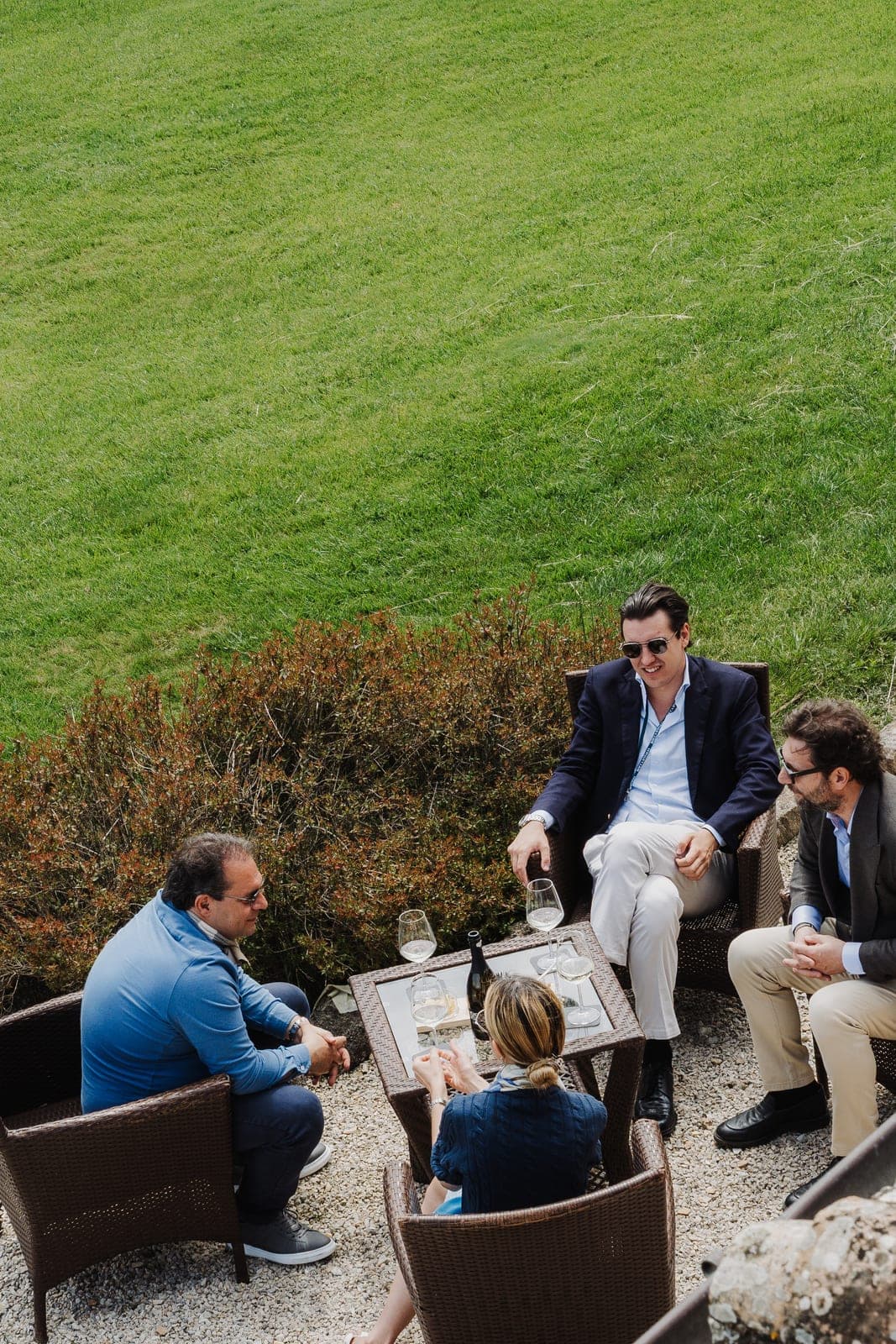 Guests chatting in a relaxed outdoor sitting area in Tuscany