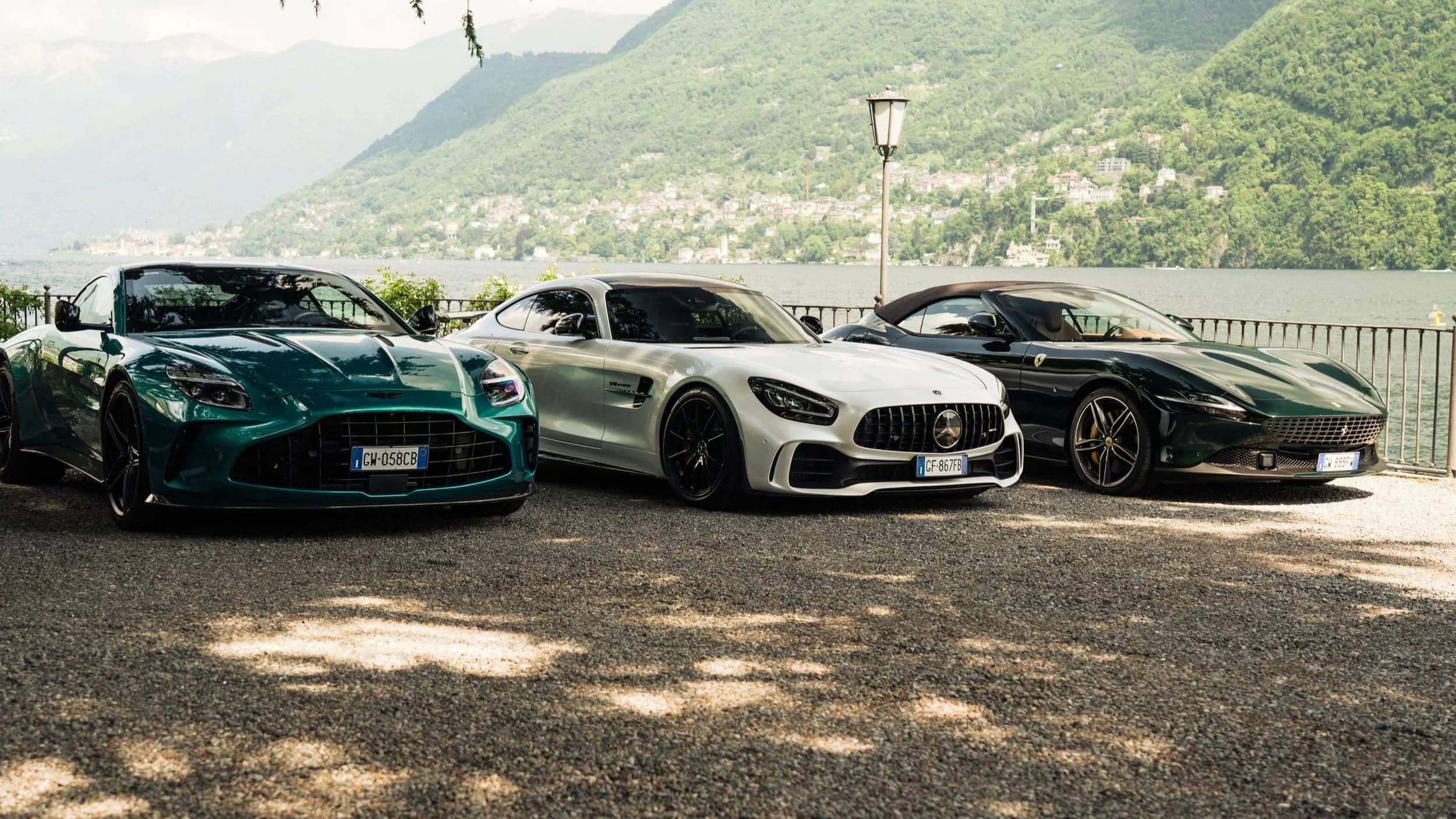 Aston Martin, Mercedes-AMG and Ferrari parked by the shore of Lake Como